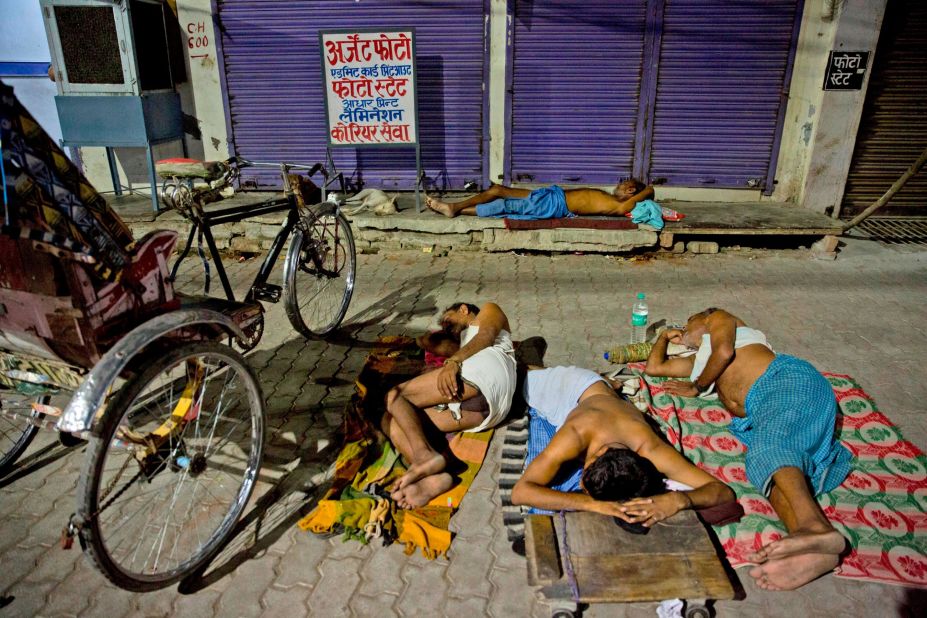 Indian laborers sleep on a side walk in Prayagraj on Sunday, June 2.