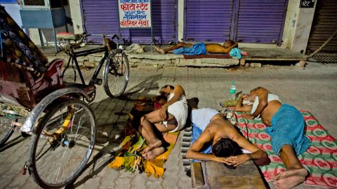 Indian laborers sleep on a side walk in Prayagraj on Sunday, June 2.