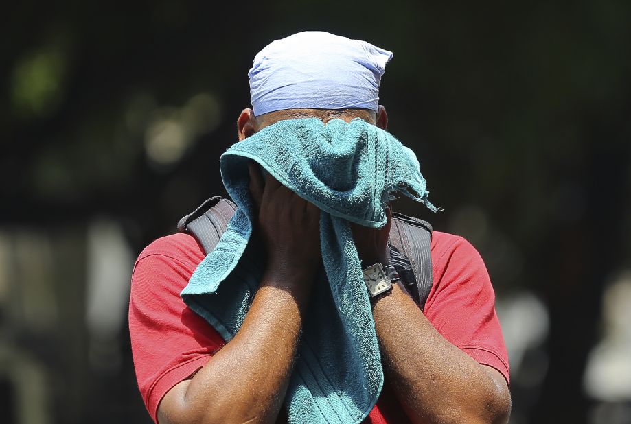 An Indian man uses a towel to wipe the sweat on his face on a hot and humid summer day in Hyderabad on Monday, June 3.