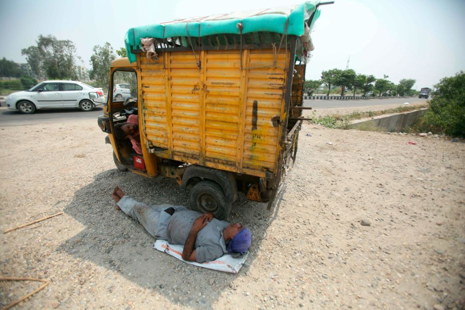 An Indian laborer takes a rest under the shade of an auto-rickshaw on a hot summer day in Jammu on Monday, June 3.