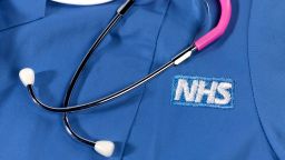 The National Health Service logo is seen on a hospital uniform.