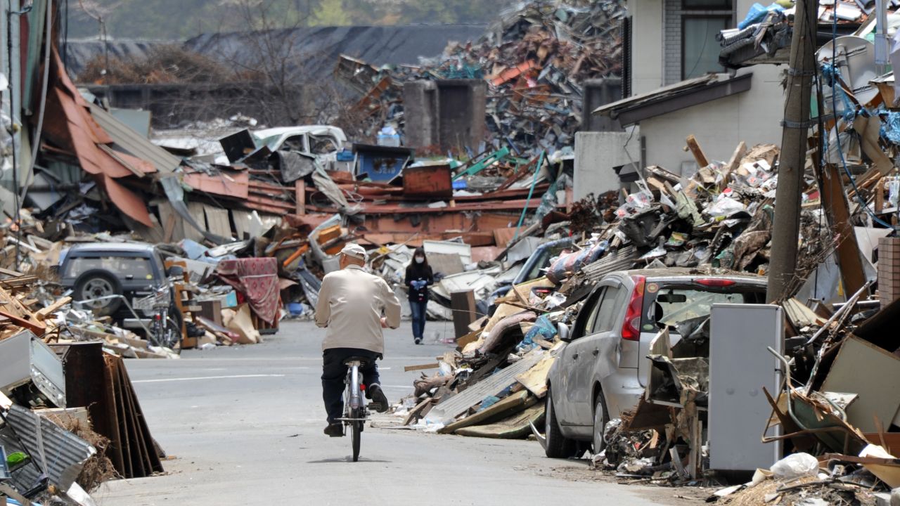 A resident cycles through the rubble of Kamaishi two months after the tsunami.