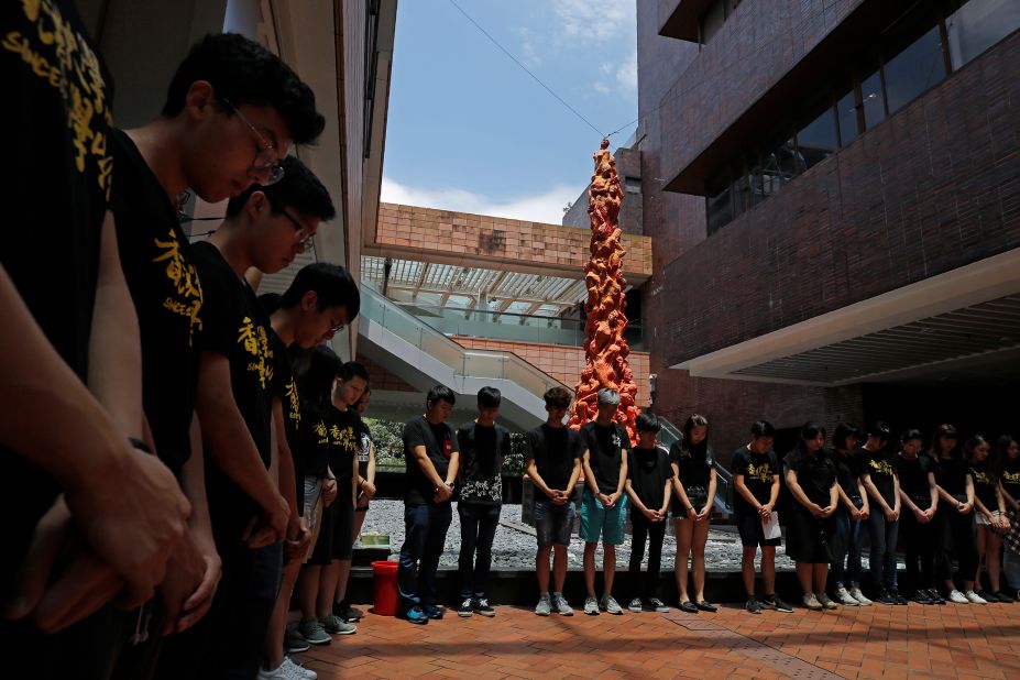 Students at the University of Hong Kong observe a minute of silence in front of the "Pillar of Shame" statue.