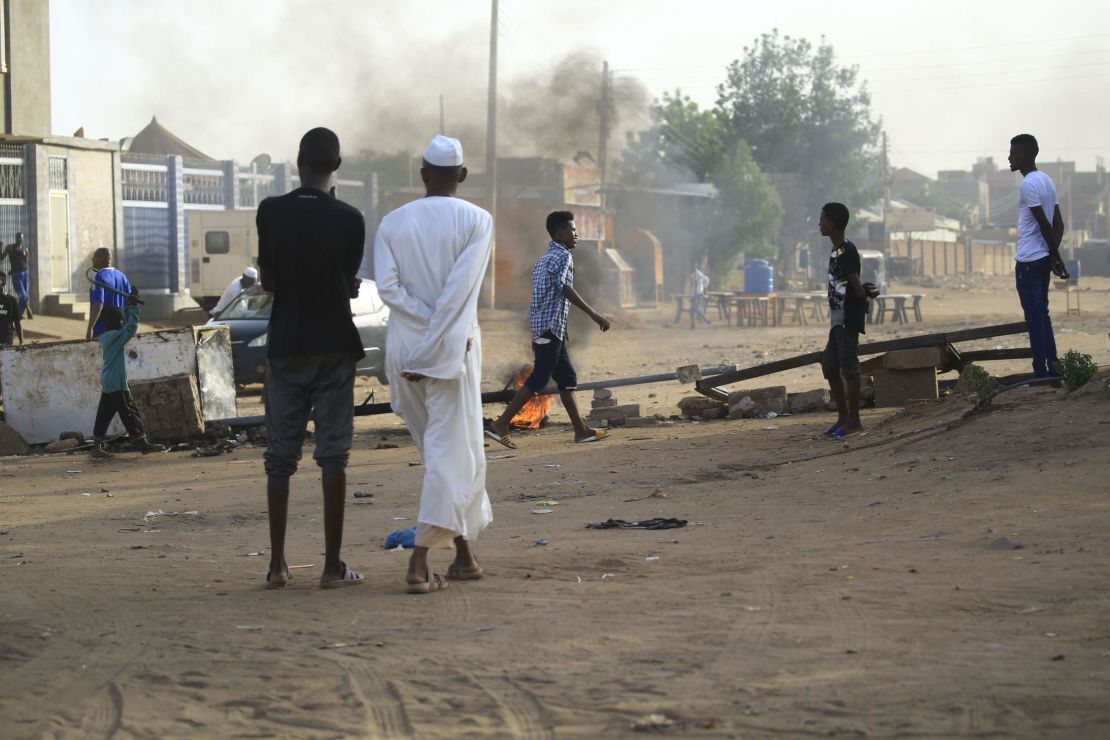 Locals set tyres on fire and block a side street leading to their neighborhood in the Sudanese capital Khartoum to stop military vehicles from driving through the area on June 4, 2019. 