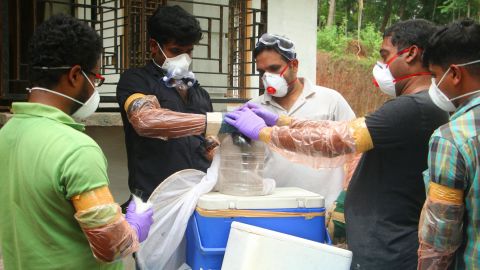 Officials deposit a bat into a container after catching it inside a well at Changaroth in Kozhikode in the Indian state of Kerala on May 21, 2018.