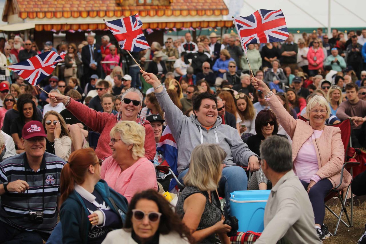 Members of the public wave flags as they watch the D-Day commemorations in Portsmouth.