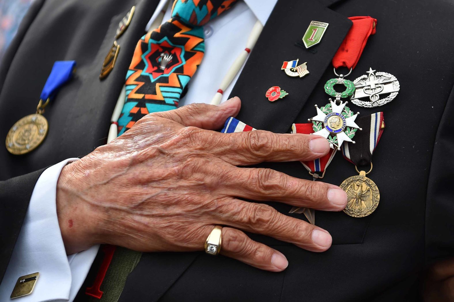 Charles Shay, a World War II veteran and Native American, holds his hand over his heart during the National Anthem at an Omaha Beach ceremony on June 5.