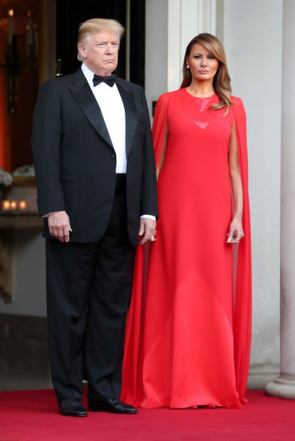 Melania Trump wears a red Givenchy cape dress to a dinner at Winfield House (the official residence of the US ambassador) for Prince Charles, Prince of Wales, and Camilla, Duchess of Cornwall. 