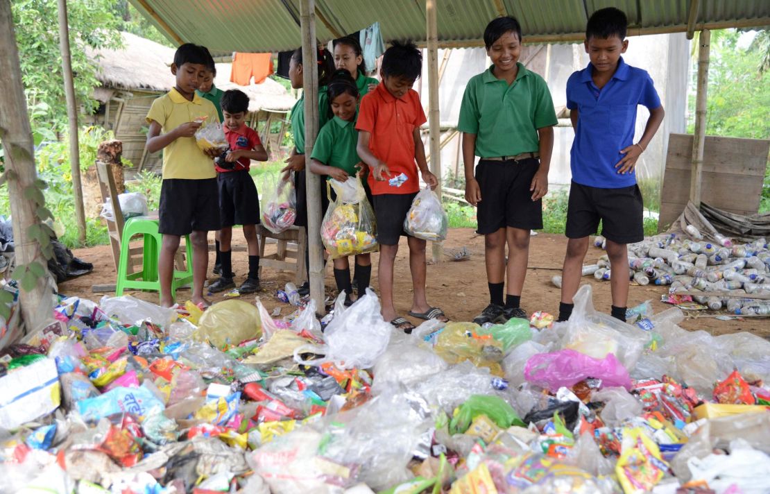 Indian students gather plastic bags before giving them as fees at the Akshar Forum school in Pamohi on the outskirts of Guwahati on May 20, 2019.