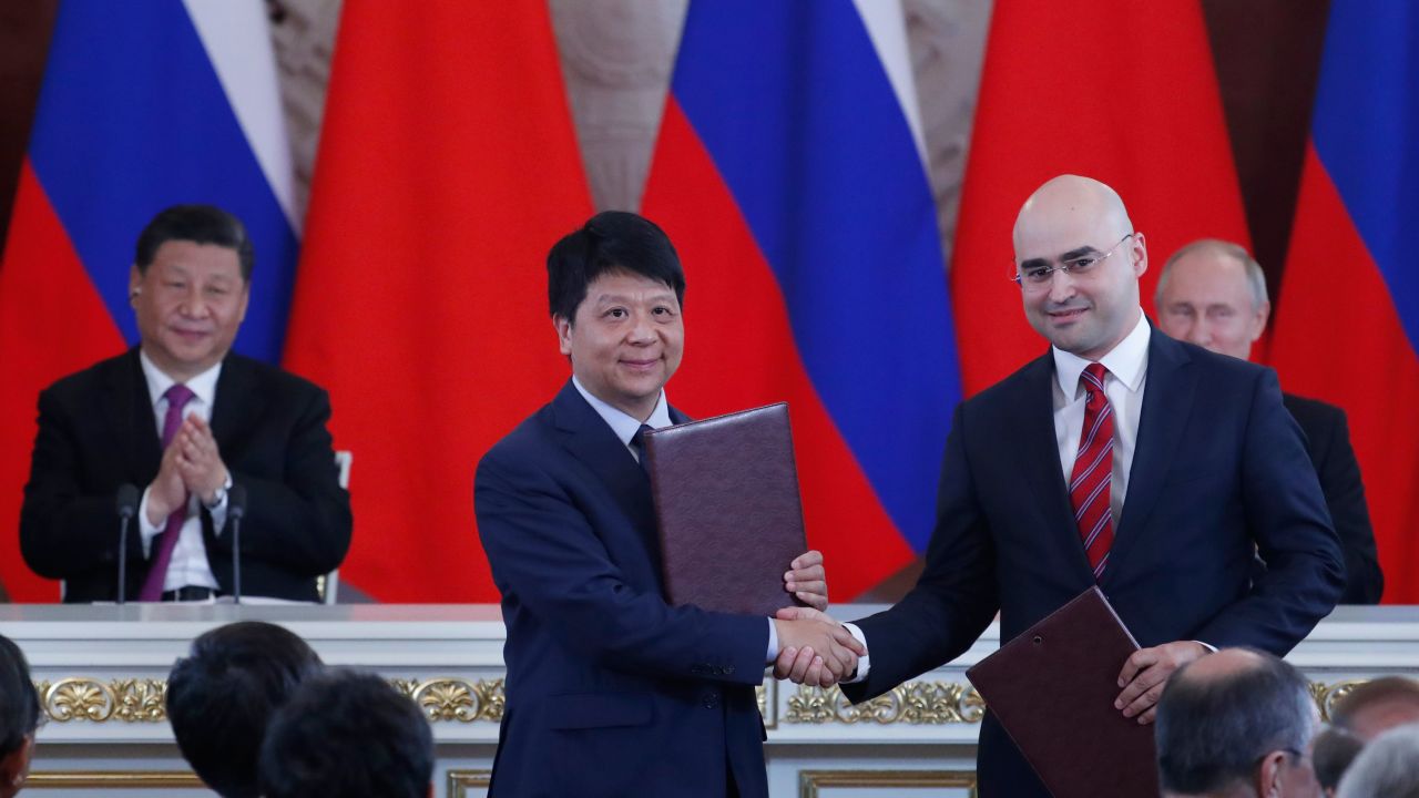 Chinese President Xi Jinping and Russian President Vladimir Putin applaud as Huawei executive Guo Ping shakes hands with Alexei Kornya, President and CEO of Russian mobile phone operator MTS.