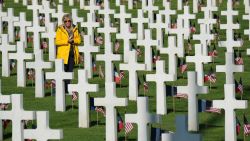 COLLEVILLE-SUR-MER, FRANCE - JUNE 06:  A visitor walks among graves at the Normandy American Cemetery on the 75th anniversary of the World War II Allied D-Day invasion on June 06, 2019 near Colleville-Sur-Mer, France. Veterans, families, visitors, political leaders and military personnel are gathering in Normandy to commemorate D-Day, which heralded the Allied advance towards Germany and victory about 11 months later. Normandy American Cemetery contains the graves of over 9,600 U.S. soldiers killed on D-Day and in the Battle of Normandy.  (Photo by Sean Gallup/Getty Images)