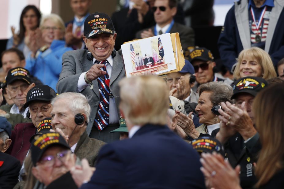 A World War II veteran shows Trump a photo of himself with the President.