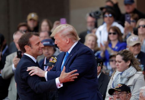 Macron and Trump embrace during the D-Day ceremony.