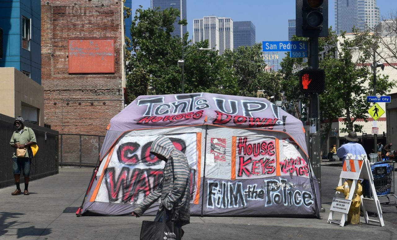 Pedestrians walk past a tent on Skid Row on May 30.
