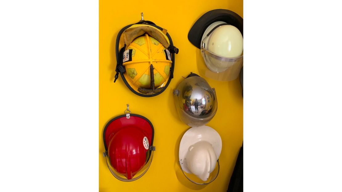 A wall in Scott Phillips-Gartner's home is adorned with firefighter helmets.
