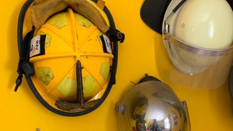A wall in Scott Phillips-Gartner's home is adorned with firefighter helmets.