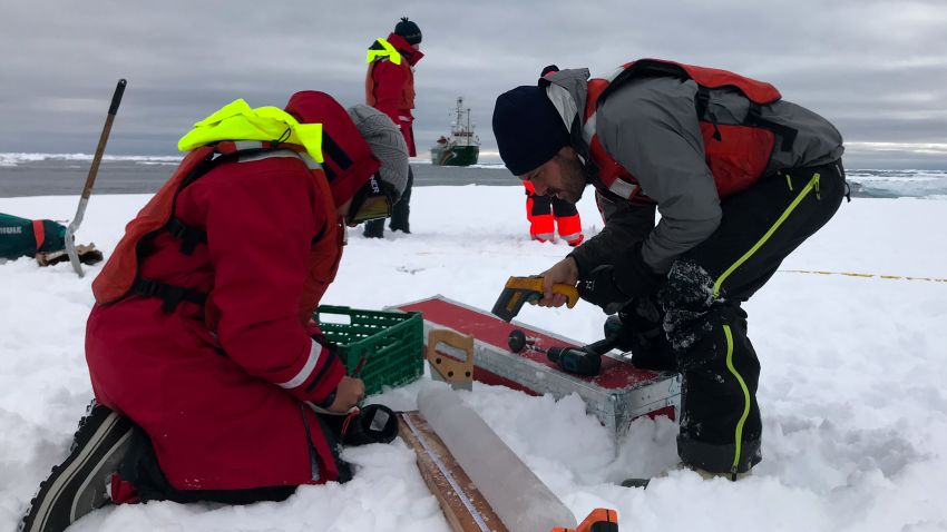 Scientist Till Wagner & team member measuring the thickness and density of a recently extracted ice core that holds frozen clues from an ice floe drifting down the Fram Strait.