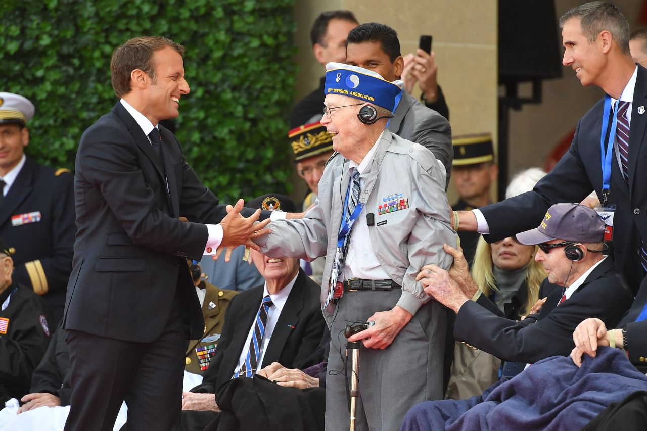 French President Emmanuel Macron (L) meets veterans during a French-US ceremony at the Normandy American Cemetery and Memorial in Colleville-sur-Mer, France, on Thursday.