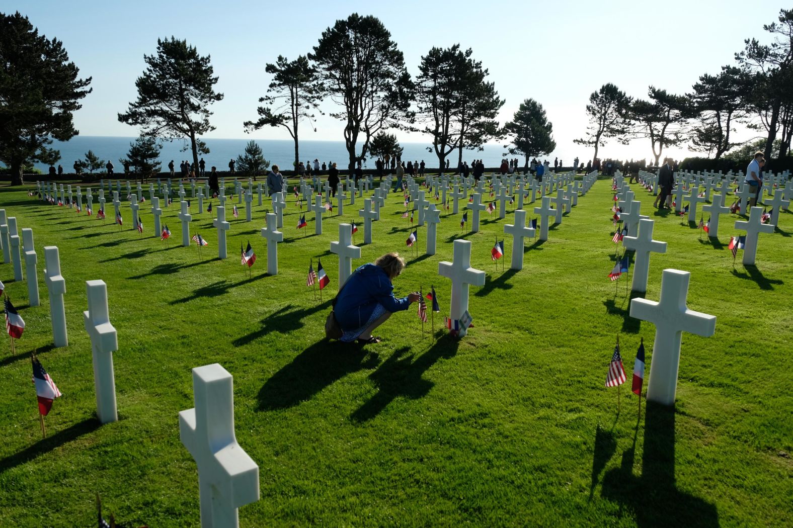 A visitor pauses to photograph one of the many crosses at the Normandy American Cemetery on the 75th anniversary of the World War II Allied D-Day invasion on Thursday near Colleville-Sur-Mer, France.