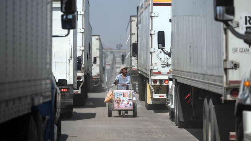 A street vendor sells ice cream to cargo trucks drivers lining up to cross to the United States at Otay commercial crossing port in Tijuana, Baja California state, on June 6, 2019, Mexico. - The US warned Mexico Thursday it needed to make more concessions on slowing migration to avoid President Donald Trump's threatened tariffs, as the Mexican leader announced he would visit the border to "defend our dignity." (Photo by Guillermo Arias / AFP)        (Photo credit should read GUILLERMO ARIAS/AFP/Getty Images)