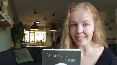 Noa Pothoven posing with her award-winning autobiography, titled Winnen of Leren ("Winning or Learning").
