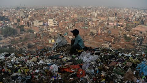 A young Indian ragpicker looks over New Delhi after collecting usable material from a garbage dump at the Bhalswa landfill site in October 2018.