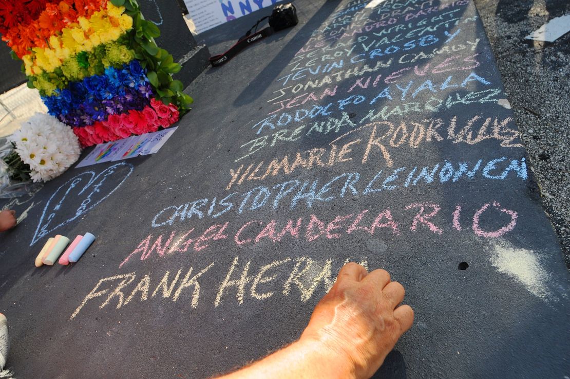 Edwin Rodriguez writes the names of the victims of the Pulse shooting in the front of the nightclub in June 2016 in Orlando, Florida.