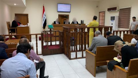 Murad Mohammad Mustafa stands with his back to the camera at the Iraqi court in in Baghdad on Monday, June 3.