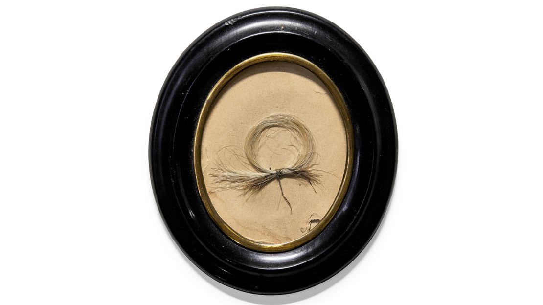 The lock of hair is secured with a silk thread and comes in a 19th-century frame.
