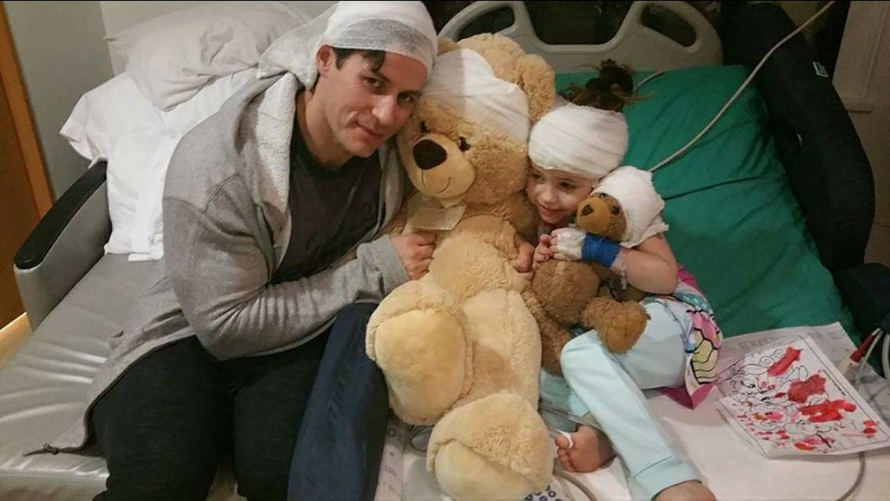 Alex Walker, 7, and her father squeeze her teddy bears while she's hospitalized for epilepsy. 