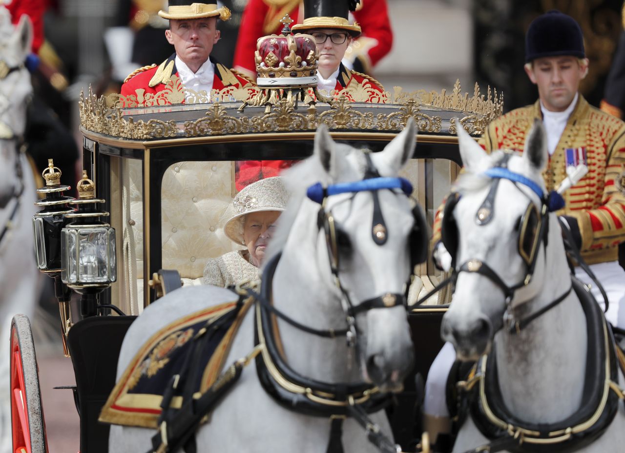 Elizabeth travels down the Mall in a carriage. When she was younger, the Queen would ride sidesaddle on horseback to greet the public. 