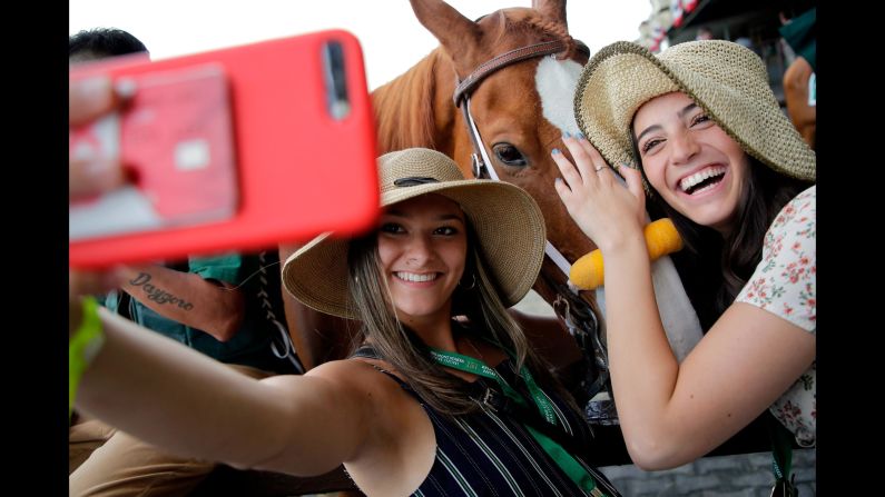 From left, Spectators Maddie Berry and Carly Zakarin pose for a selfie with horse Red Shogun.
