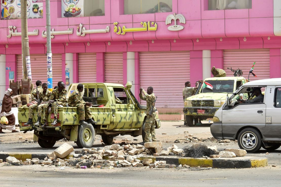 Sudanese soldiers guard a street in Khartoum on Sunday after police fired tear gas at protesters.