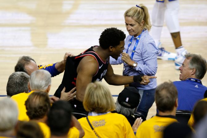 Kyle Lowry of the Toronto Raptors argues with Warriors minority investor Mark Stevens (blue shirt) after Lowry chased down a loose ball in the second half against the Golden State Warriors during Game Three of the 2019 NBA Finals at ORACLE Arena on June 5, 2019 in Oakland, California.