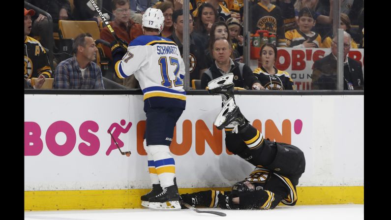 Boston Bruins defenseman Charlie McAvoy (73) is checked by St. Louis Blues left wing Jaden Schwartz (17) during the first period in game five of the 2019 Stanley Cup Final at TD Garden.