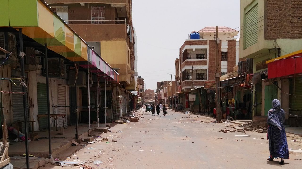 A Sudanese woman walks past closed shops in a commercial street in Khartoum's twin city Omdurman on June 9.