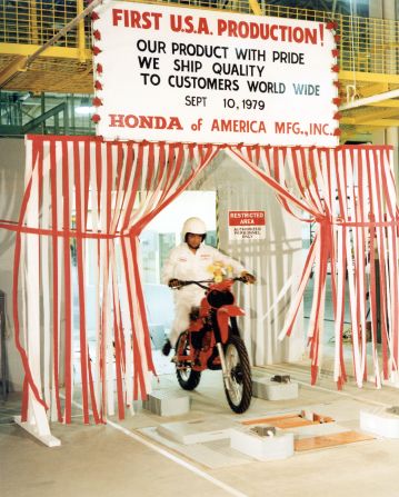 Hot off the assembly production line, a Japanese worker showcases the CR250R motorcycle model at Honda's Marysville plant.