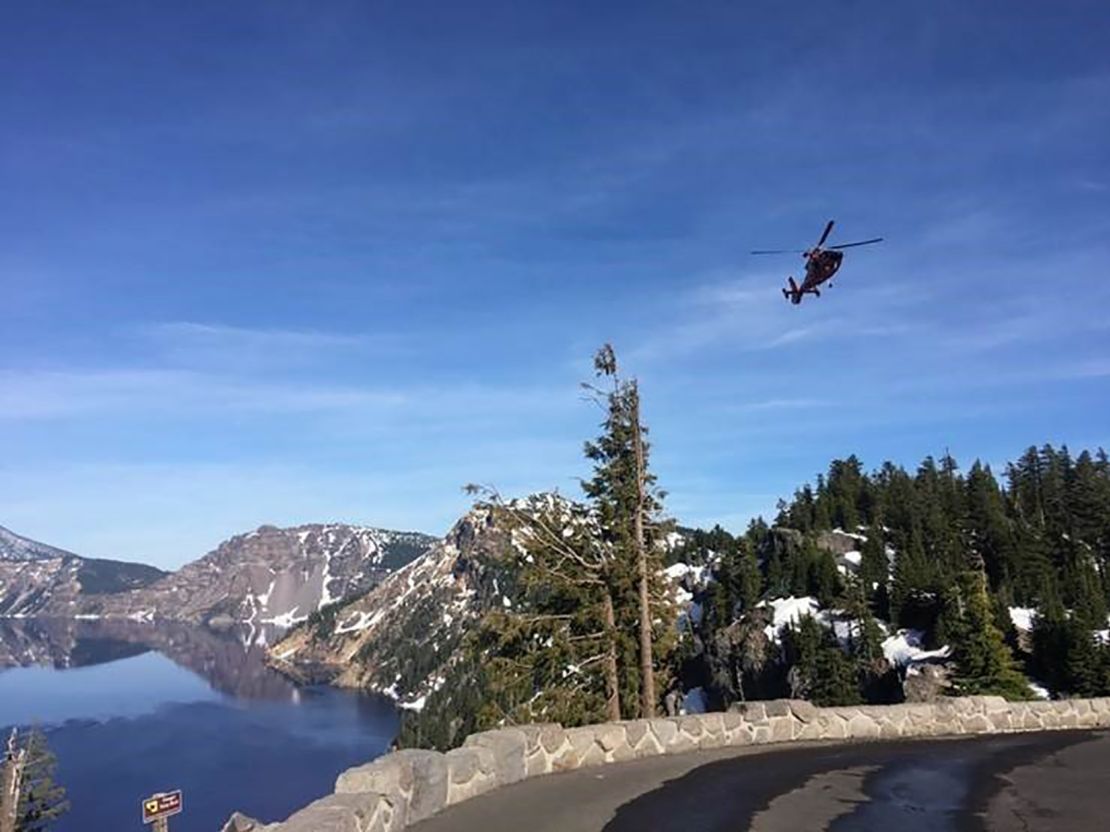 A helicopter flies over Crater Lake.