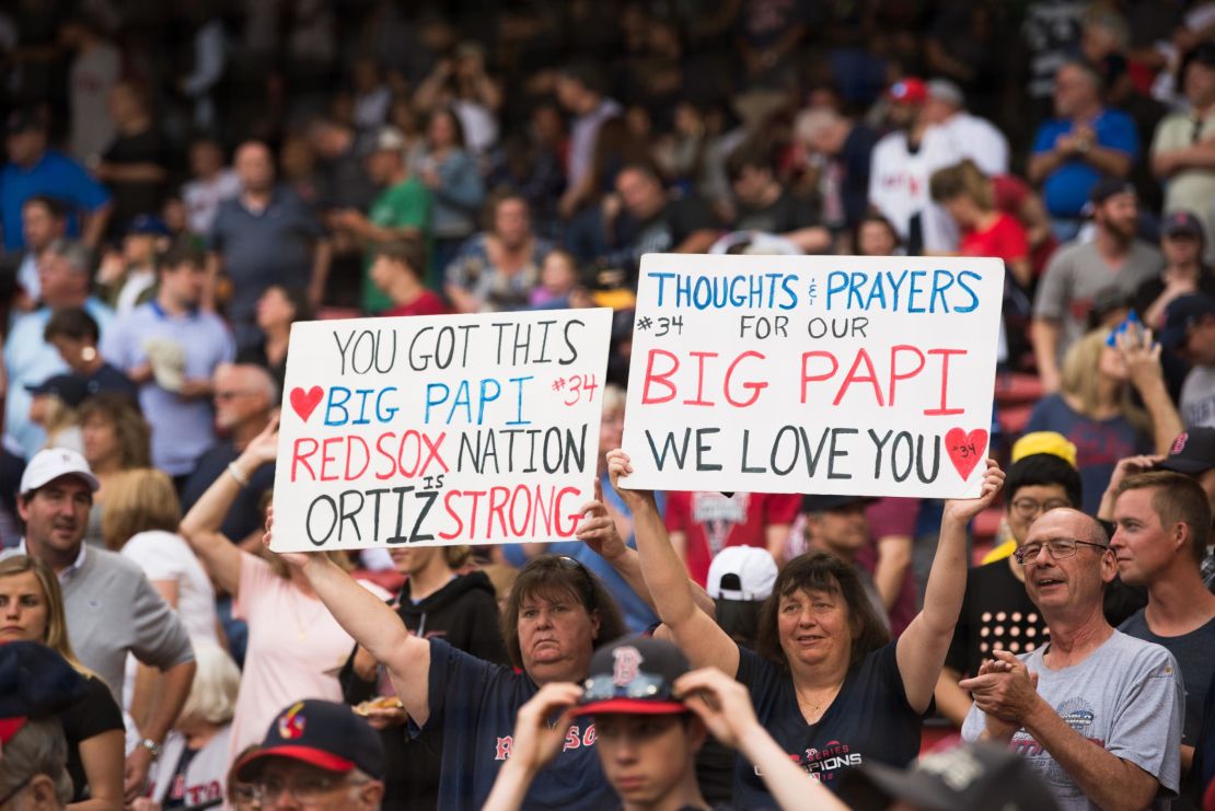 Fans hold up signs showing support for former Red Sox player David Ortiz before the start of the game against the Texas Rangers at Fenway Park on Monday. 