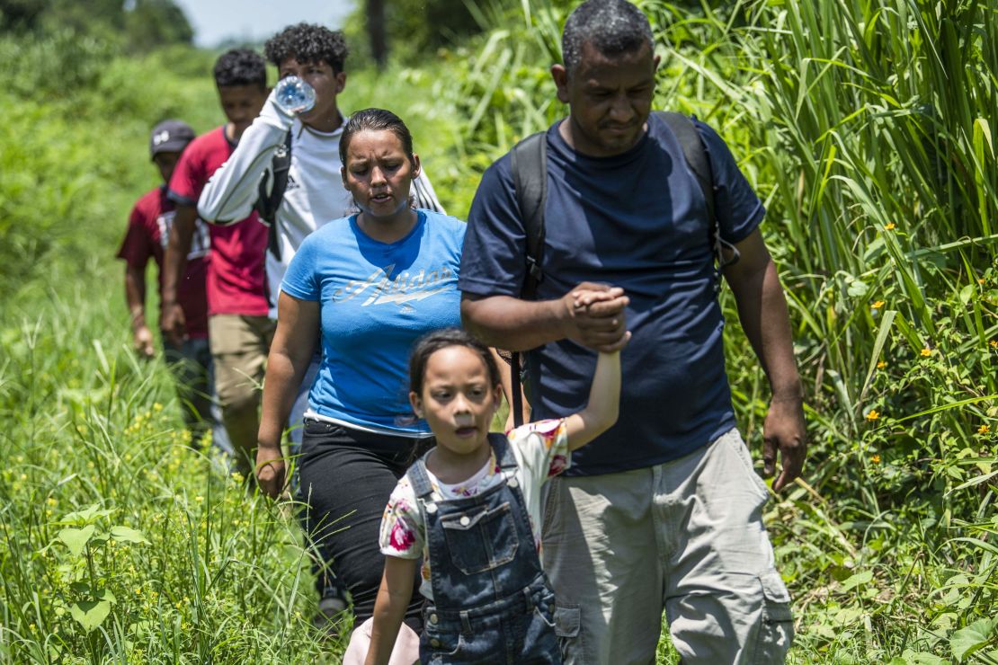 A Honduran family heading to the US tries to avoid detection by Mexican authorities on the outskirts of Huixtla on June 9. 
