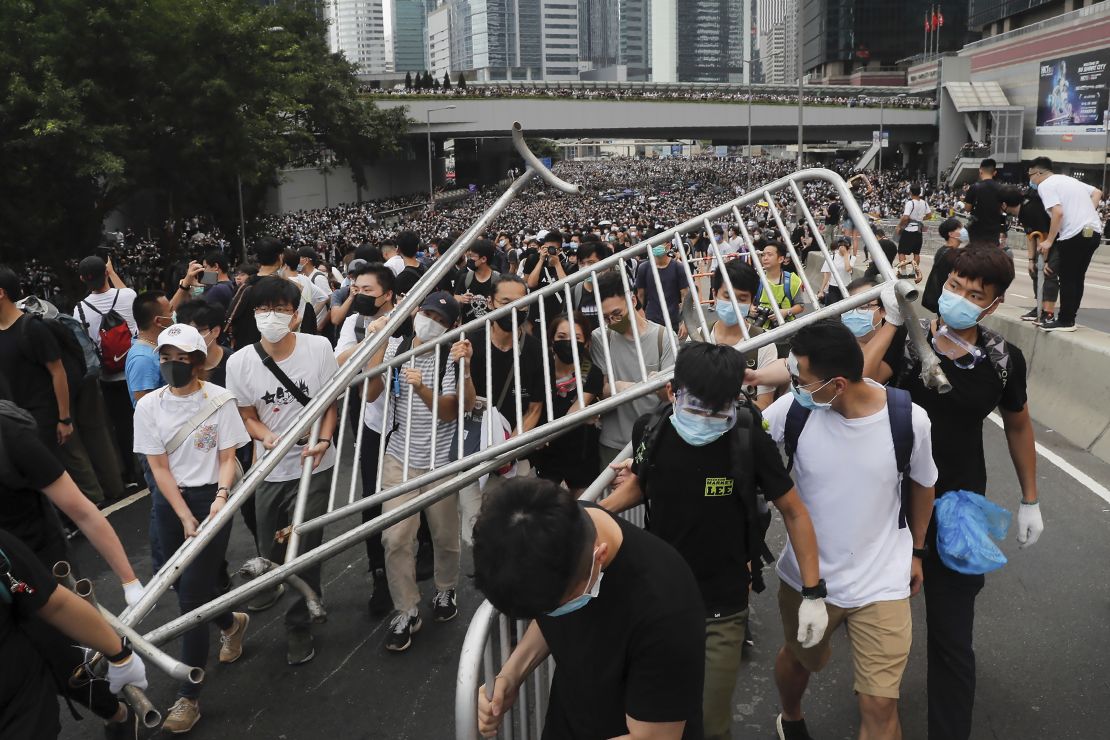 Protesters carry barricades as they march toward the Legislative Council.