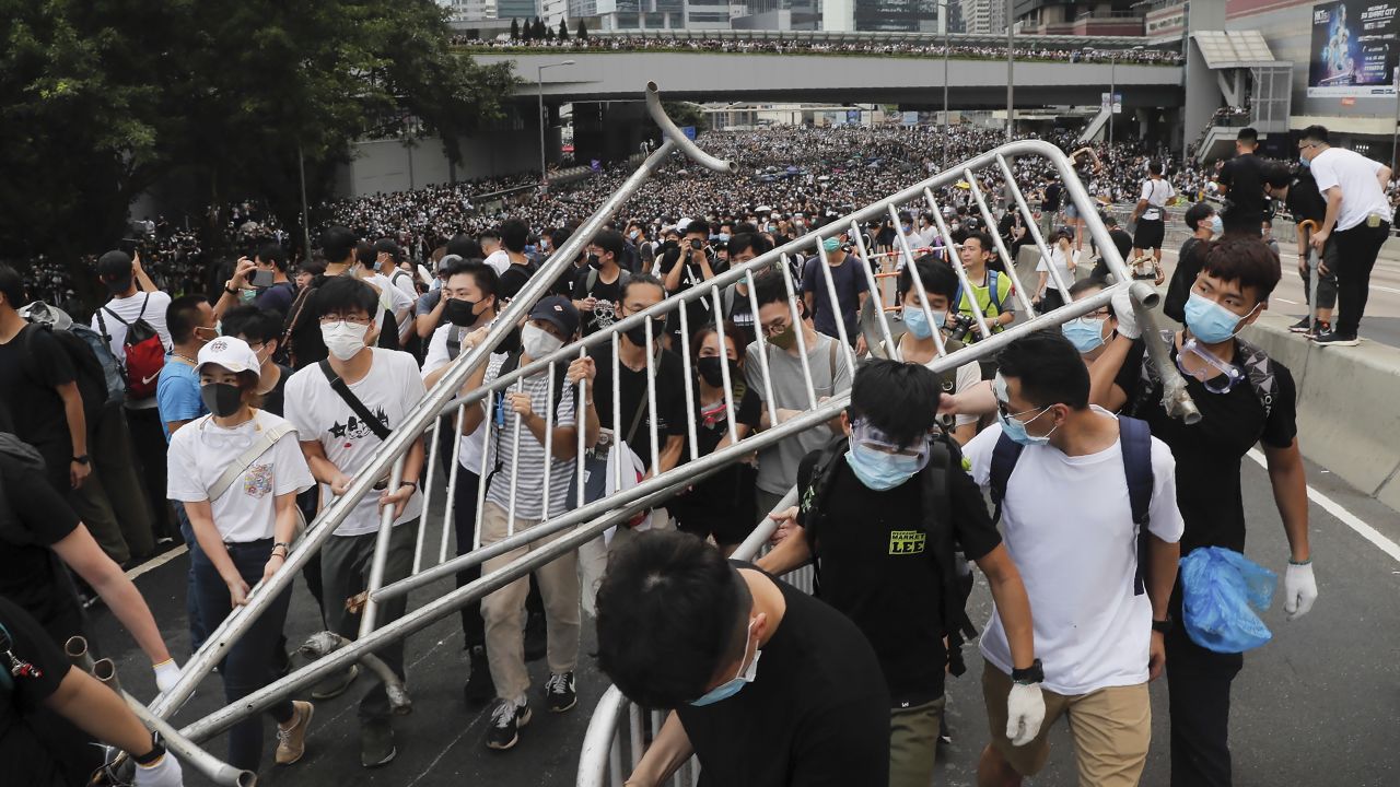 Protesters carry barricades as they march toward the Legislative Council.