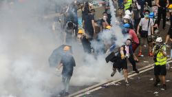A protester throws a tear gas canister fired by police during a rally against a controversial extradition law proposal outside the government headquarters in Hong Kong on June 12, 2019. - Violent clashes broke out in Hong Kong on June 12 as police tried to stop protesters storming the city's parliament, while tens of thousands of people blocked key arteries in a show of strength against government plans to allow extraditions to China. (Photo by DALE DE LA REY / AFP)
