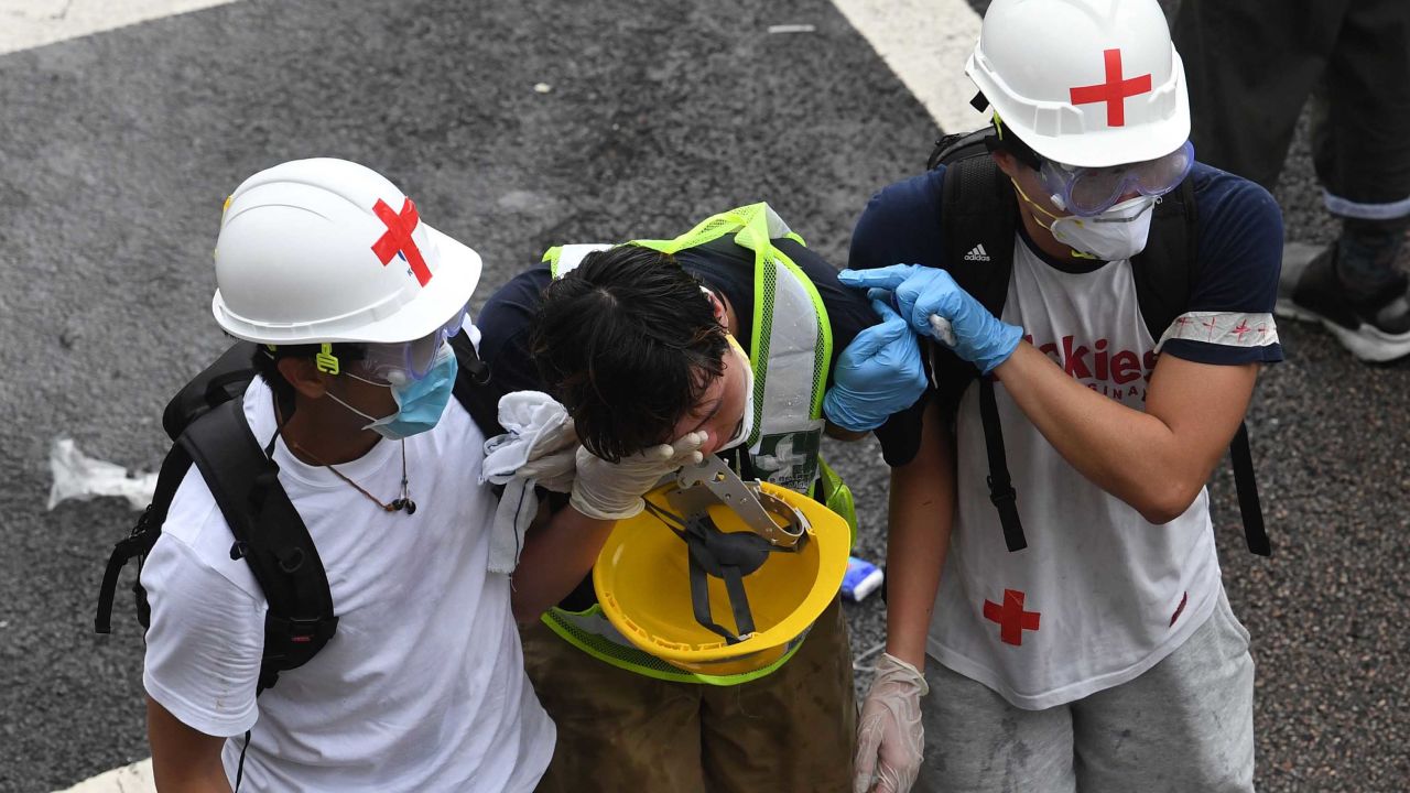 A protester is helped by medical volunteers after being hit by tear gas fired by the police during a rally against a controversial extradition law proposal in Hong Kong on June 12, 2019. - Violent clashes broke out in Hong Kong on June 12 as police tried to stop protesters storming the city's parliament, while tens of thousands of people blocked key arteries in a show of strength against government plans to allow extraditions to China. (Photo by Anthony WALLACE / AFP)        (Photo credit should read ANTHONY WALLACE/AFP/Getty Images)