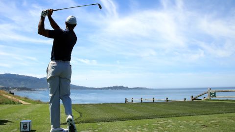 Tiger Woods tees off on the iconic short seventh hole at Pebble Beach.