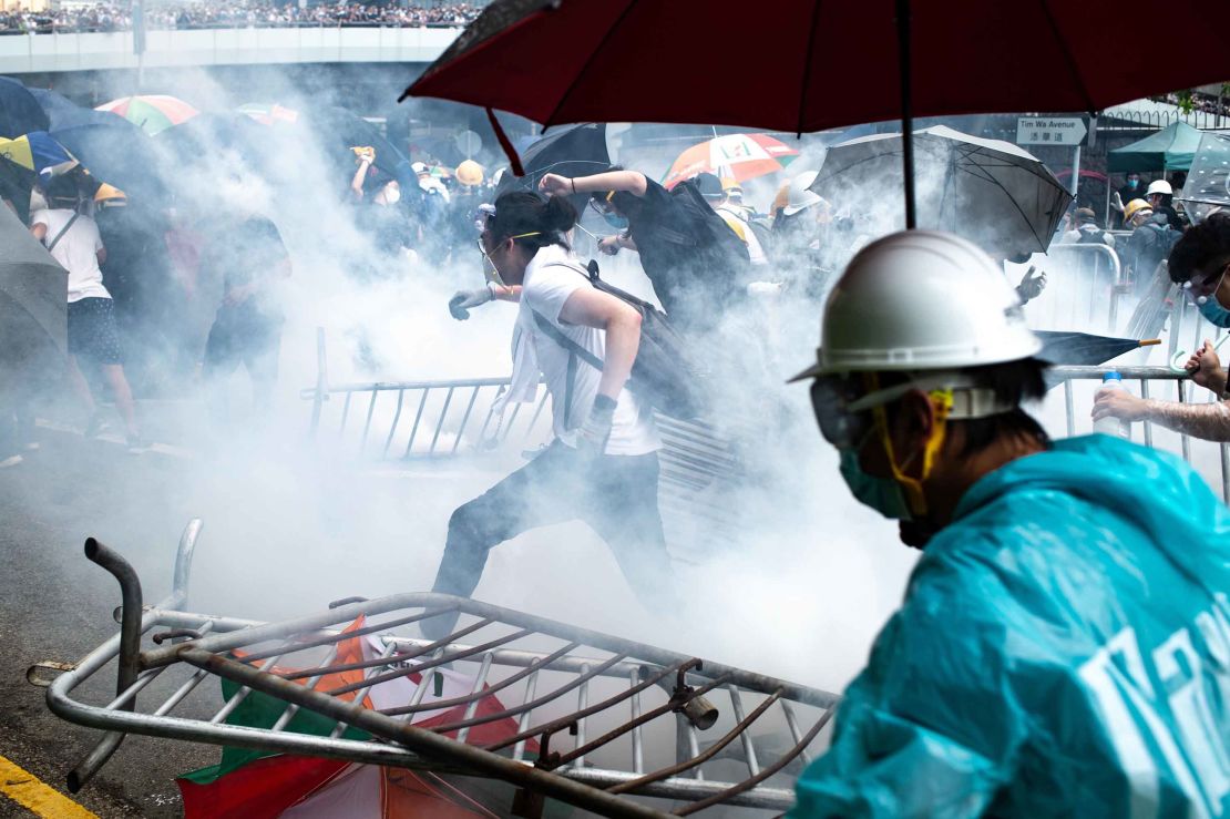 Protesters run after police fired tear gas outside government headquarters on June 12.