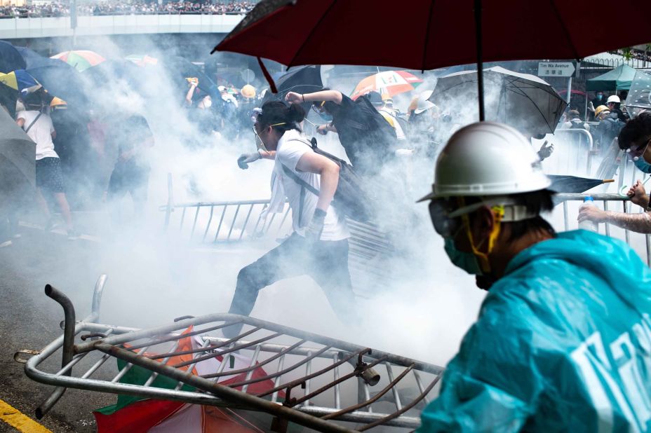 Protesters run after police fired tear gas on Wednesday, June 12.