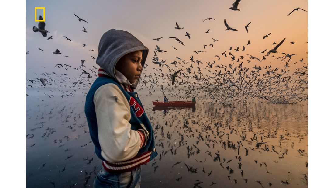 <strong>People honorable mention -- "Mood":</strong> The honorable mention in this category of the <a href="http://natgeo.com/travelphotocontest" target="_blank" target="_blank">2019 National Geographic Travel Photographer of the Year Contest</a> was Navin Vatsa. "I captured this layered moment during sunrise along the banks of the Yamuna River in Delhi, India," says the photographer. "This boy was thinking silently, and visitors were enjoying the loud musical chirping of thousands of seagulls."