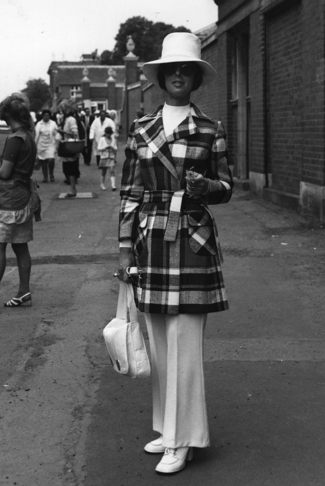 A woman wears a trouser suit and jacket at Royal Ascot in 1970.