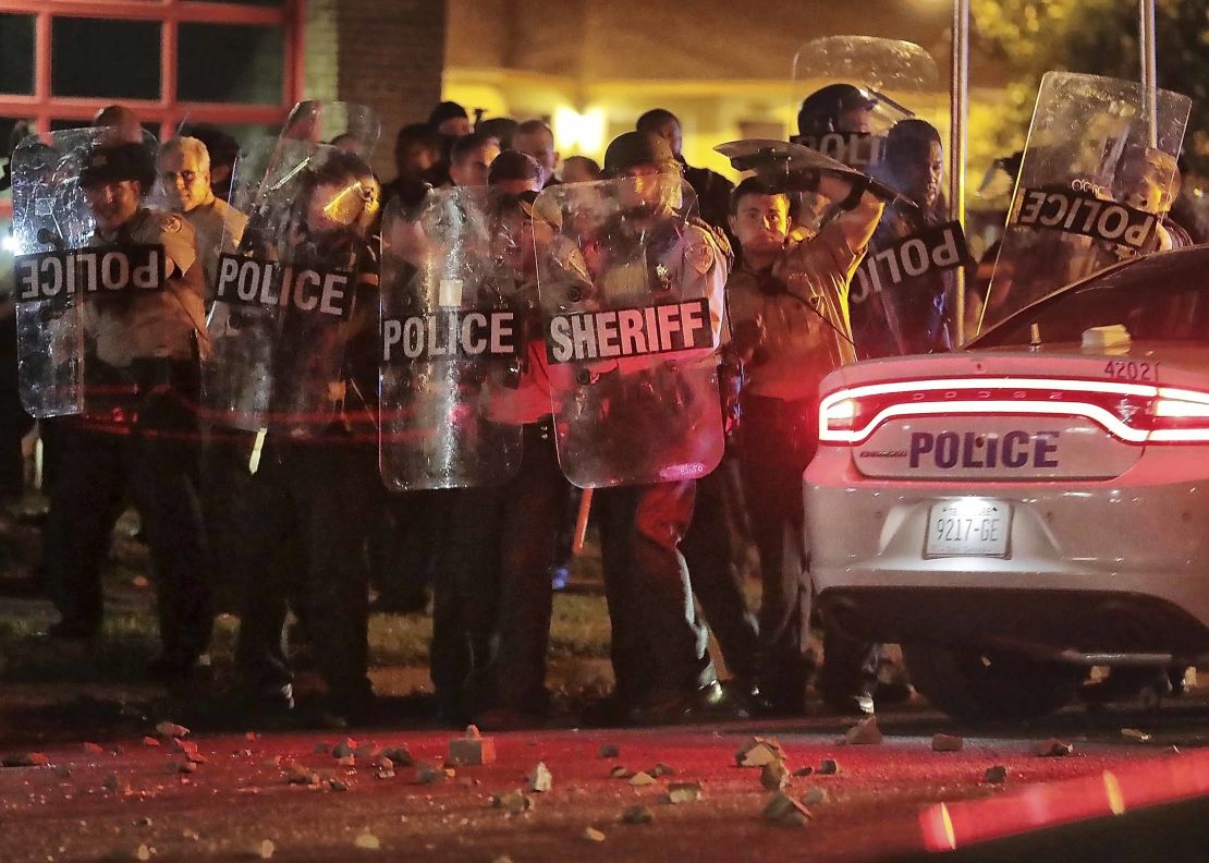 Shelby County sheriff's deputies brace against the crowd as protesters throw rocks Wednesday night. 